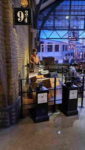 Kuvassa näkyy Laituri 9 ¾ (Platform 9 ¾) ja matkatavarakärryt