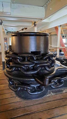 Lähikuva HMS Warriorin ankkurikapstanin alaosasta ja sen ympärille tiukasti kelatusta valtavasta rautaisesta ankkuriketjusta.