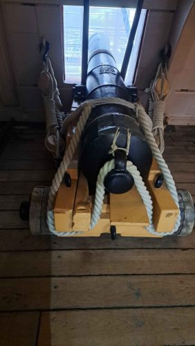 HMS Victoryn suustaladattava tykki keltaisella puisella laivastoalustallaan suoraan takaa kuvattuna